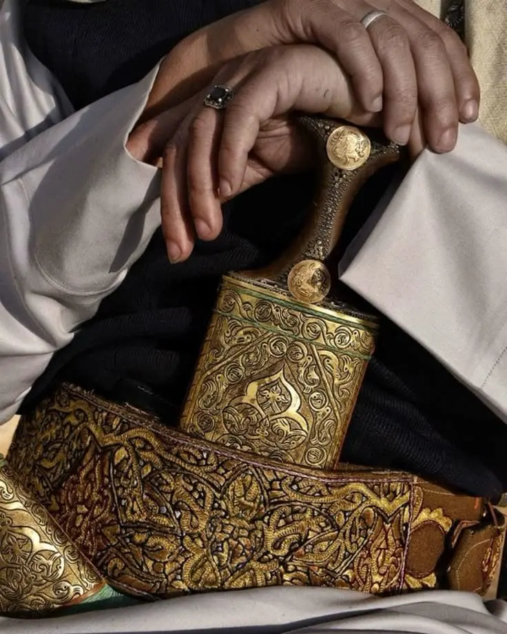A finely engraved gold Yemeni Janbiah, the traditional curved ceremonial dagger and its ornate belt.